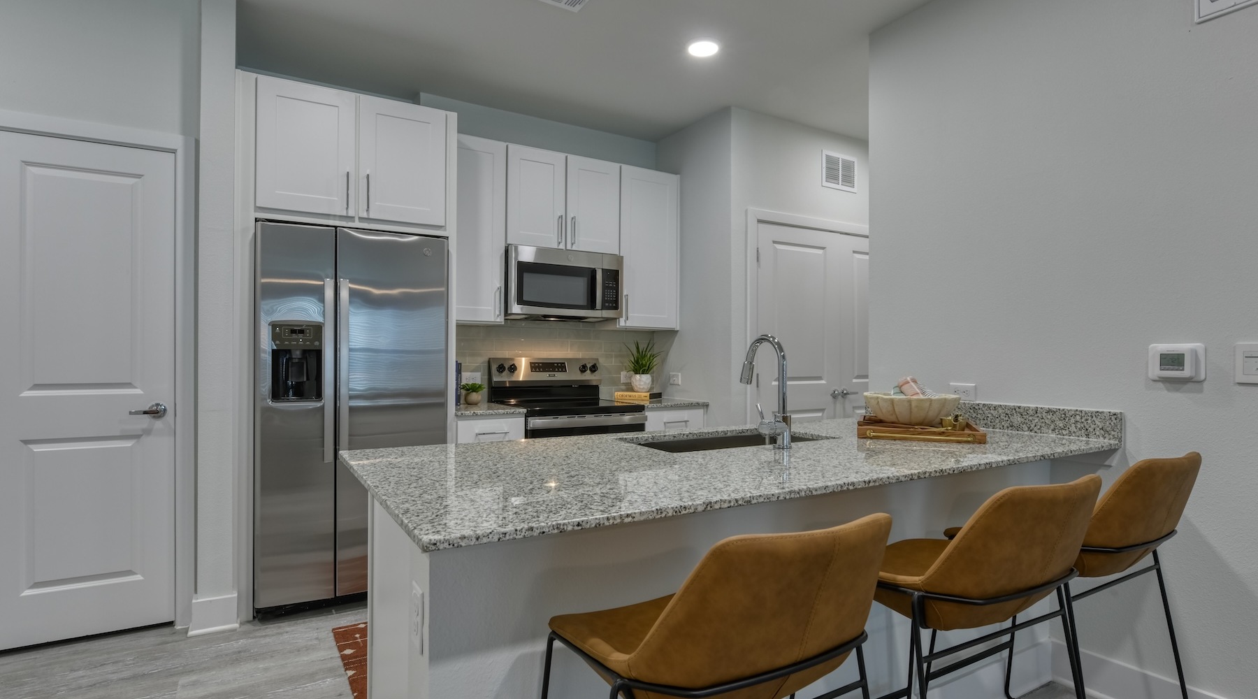 A kitchen with stainless steel appliances and white cabinets at Alta Westover Hills luxury apartments in San Antonio, TX.