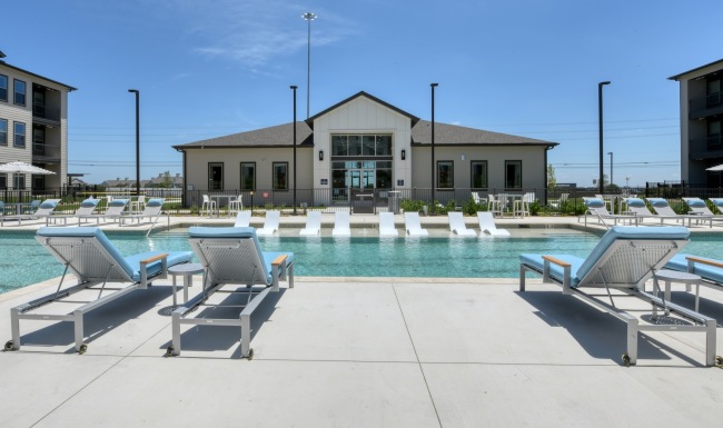 Pool with sun shelf and view of the clubhouse at Alta Westover Hills apartments in San Antonio, TX.